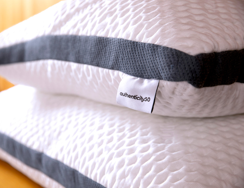 2 authenticity50 custom comfort pillows stacked on top of each other