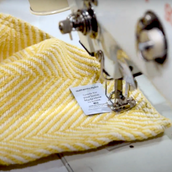Prairie yellow heritage blanket with authenticity50 made in usa label being sewn on
